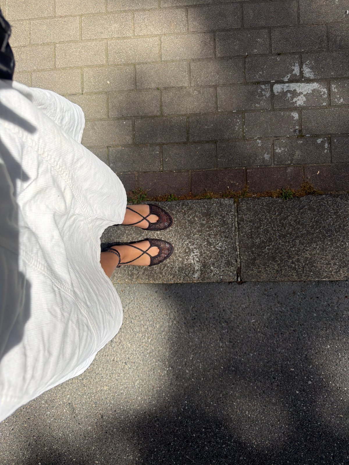 Person in white skirt photographed on Milan street