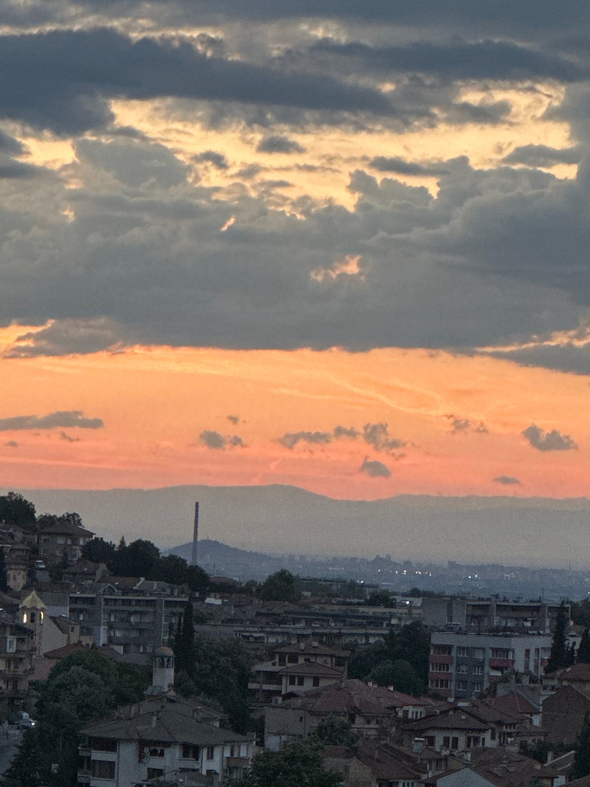 Dramatic sunset clouds roll over Asenovgrad from an elevated viewpoint