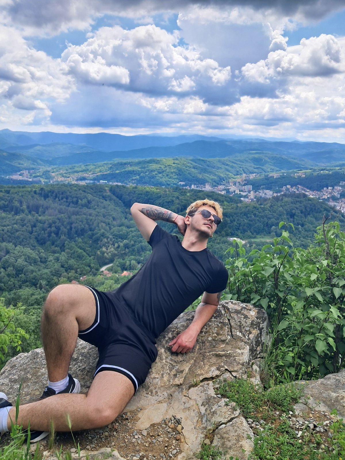 Three men sightsee from rocky outcrop overlooking Gabrovo valley