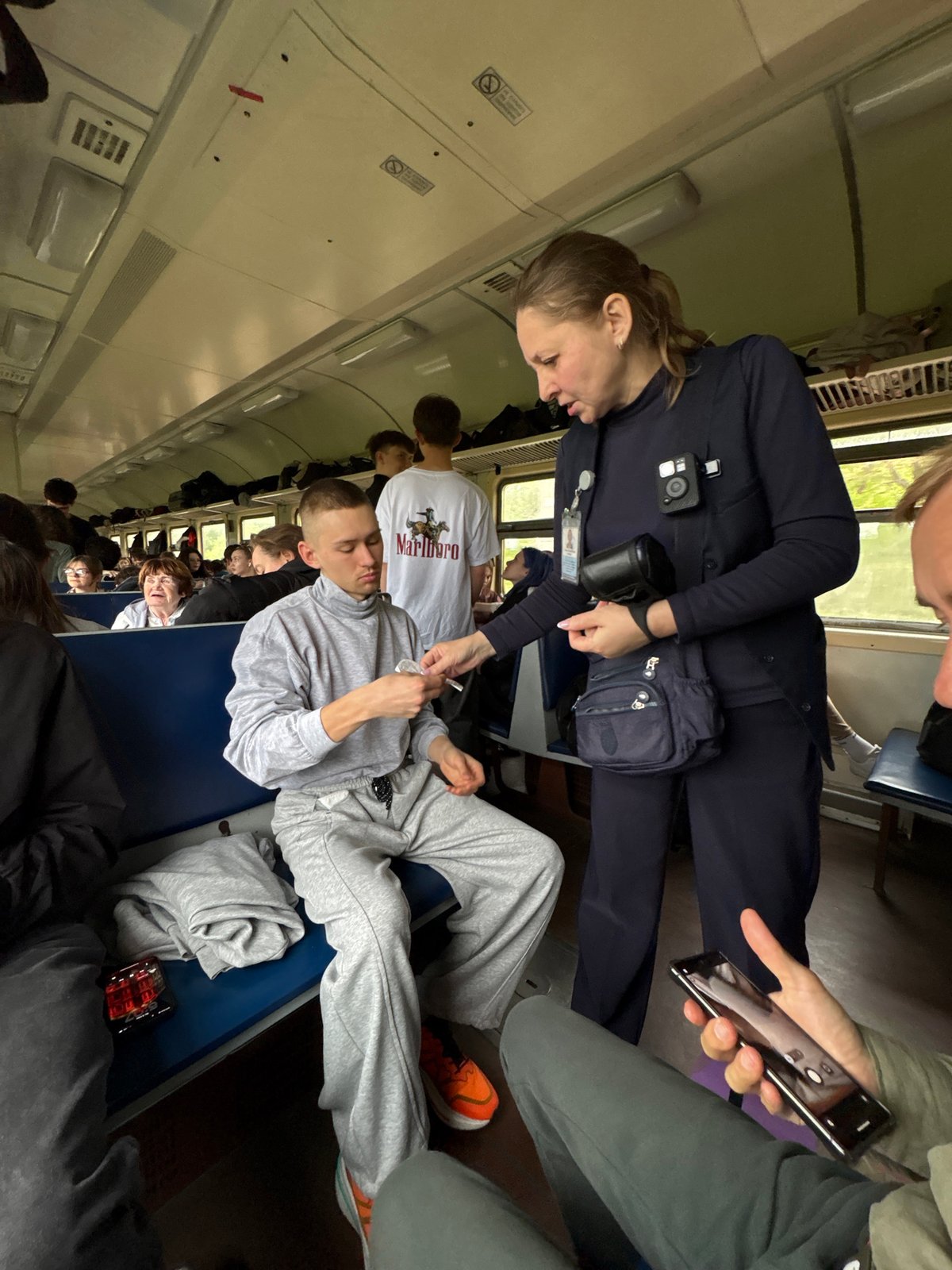 Ticket inspector checks passengers aboard train in Verkhneadagum, Russia