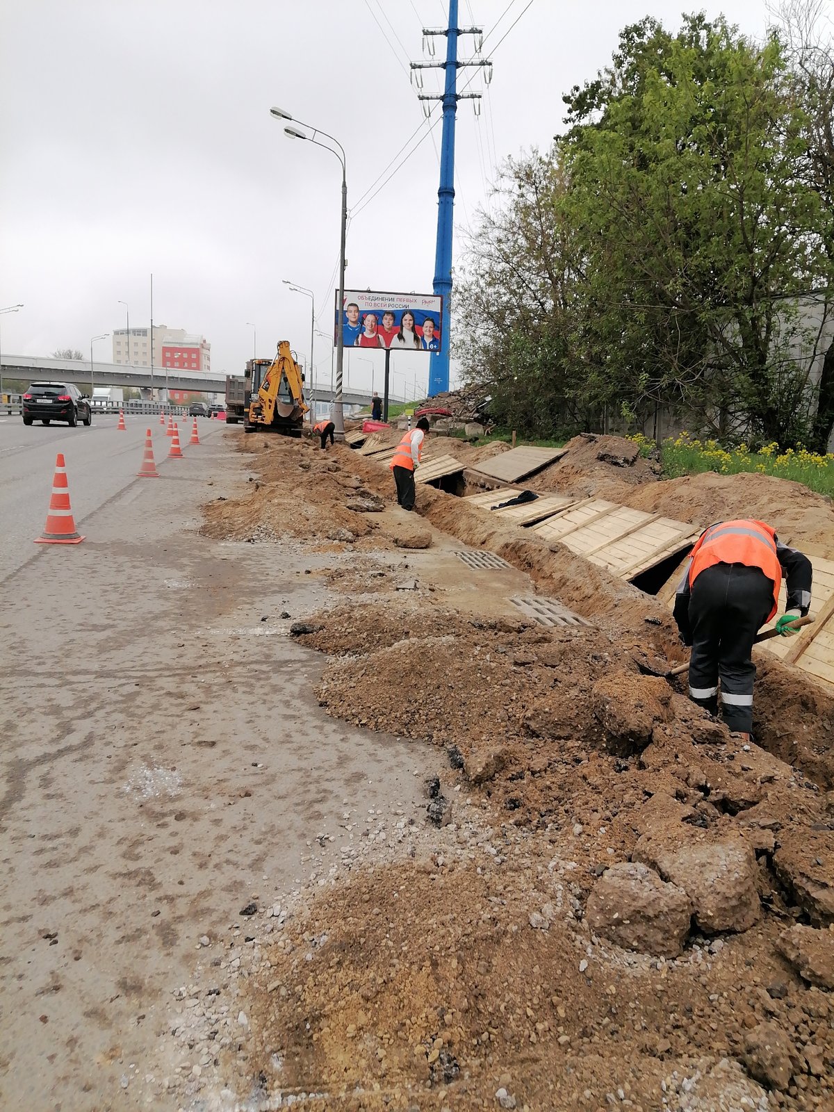 Moscow road construction crew digs trenches, installs infrastructure