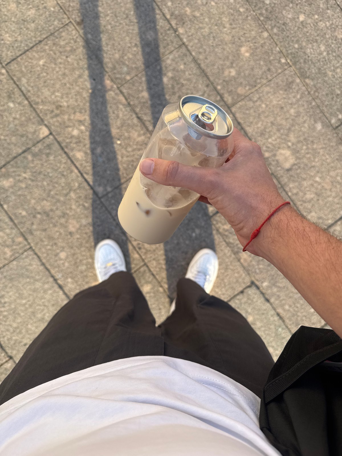 Summertime hangout at a Moscow transit stop, drinks and phones out