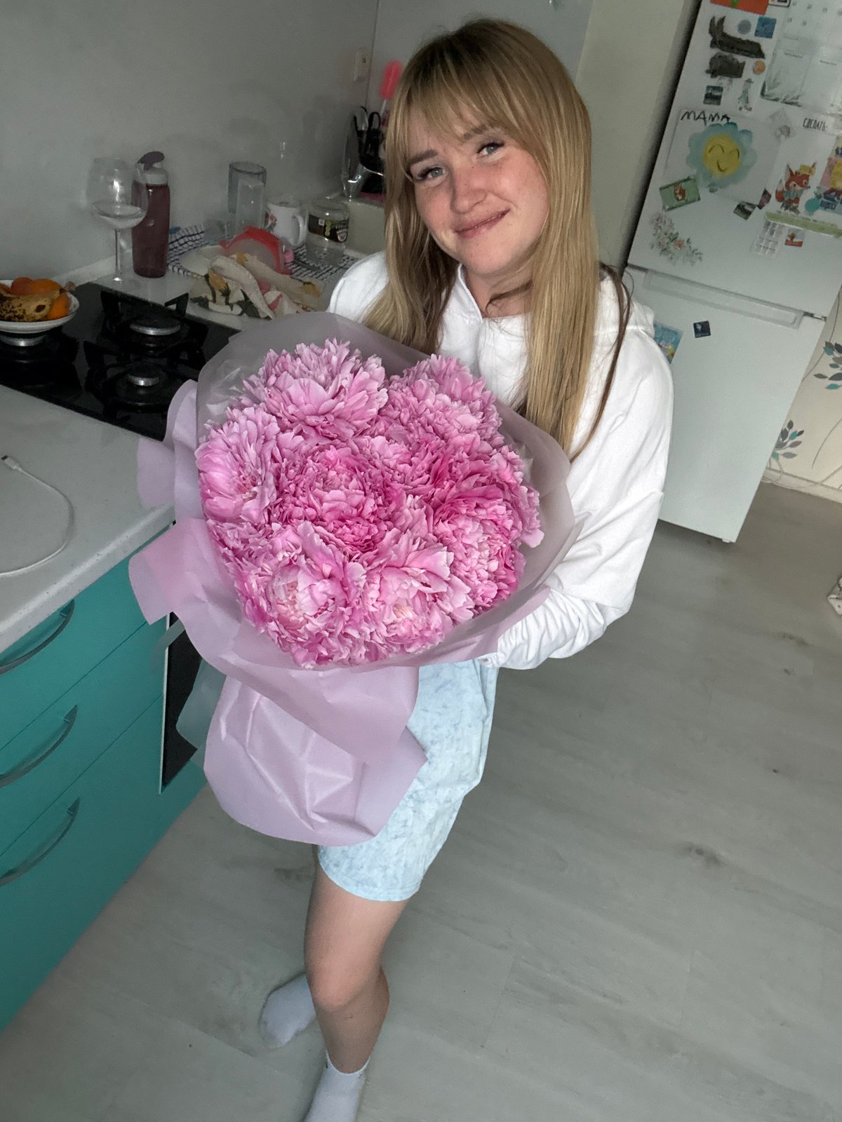 Pink peonies, fresh strawberries, and fritters at home in Russia