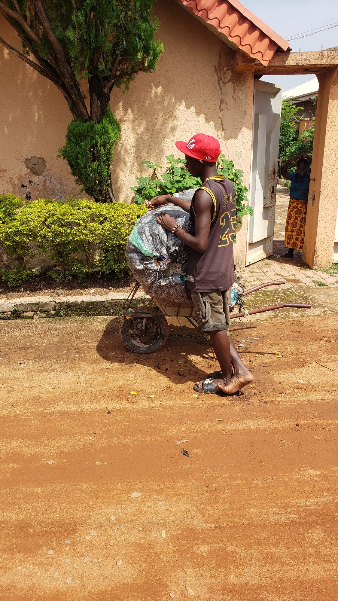 Wheelbarrow hauling goods through Sabon Tasha on a June morning