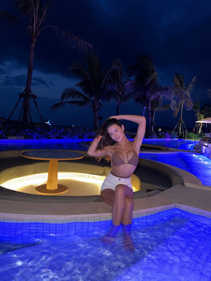Woman poses for photos at poolside in Thailand
