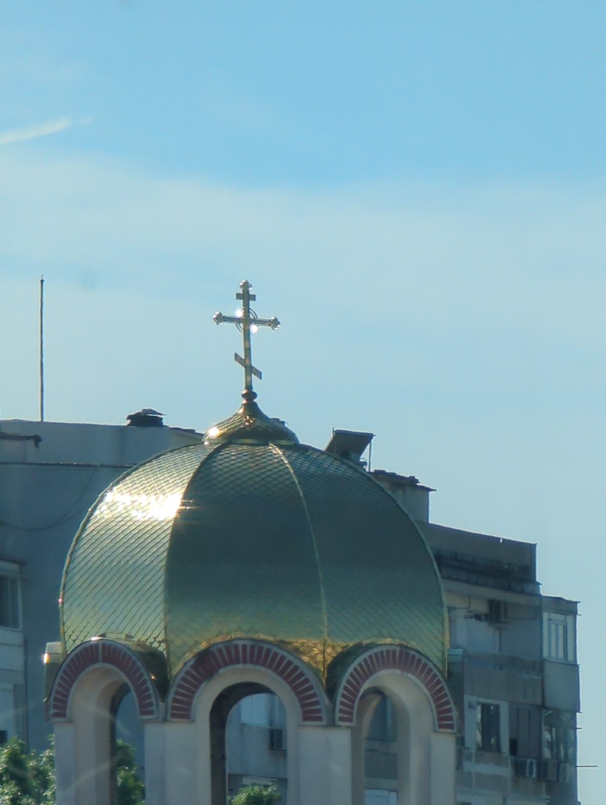 Cat naps by a curtain, golden dome gleams in the sun