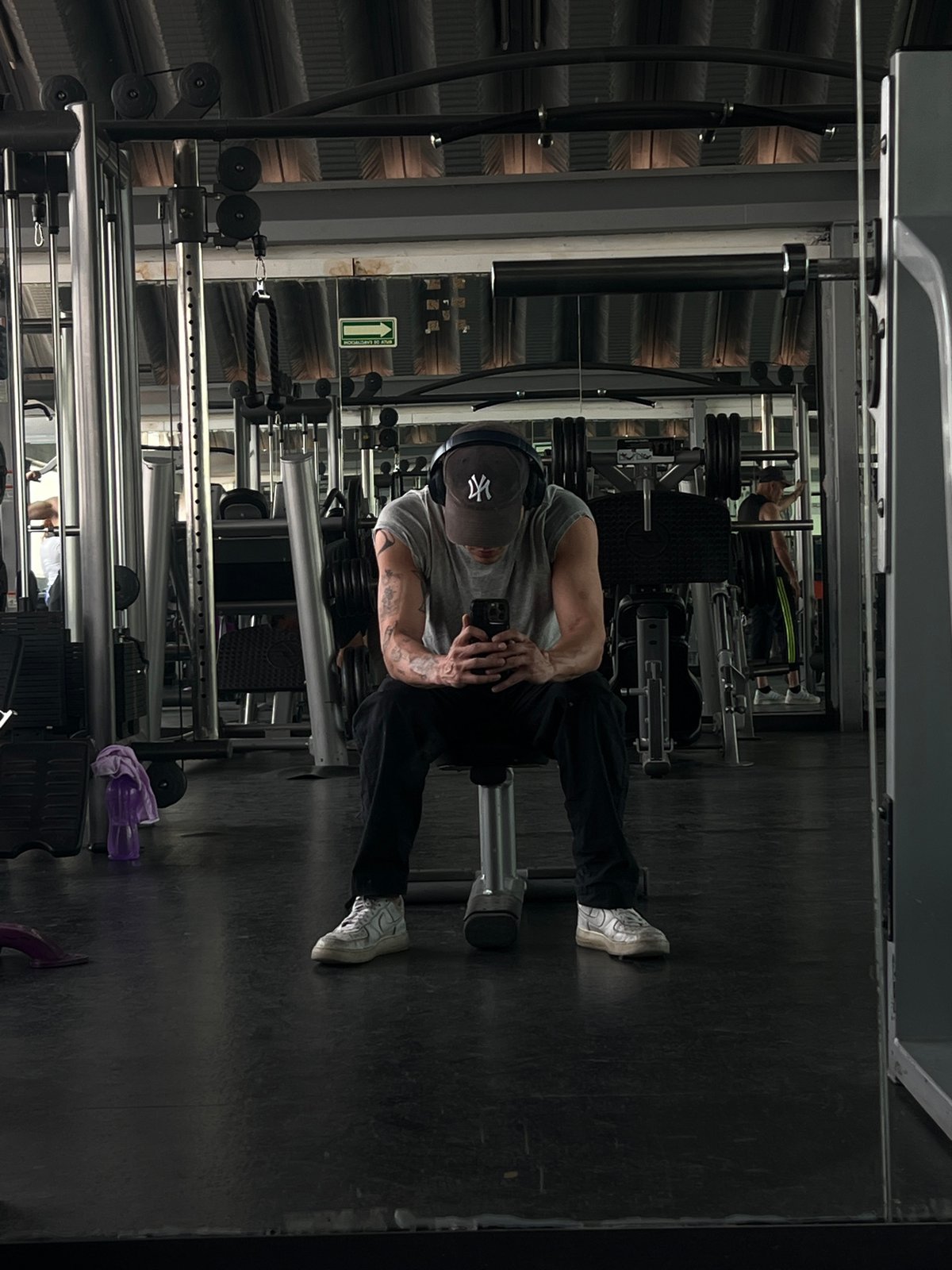 Man poses at Mexico City gym; bulldog rests nearby
