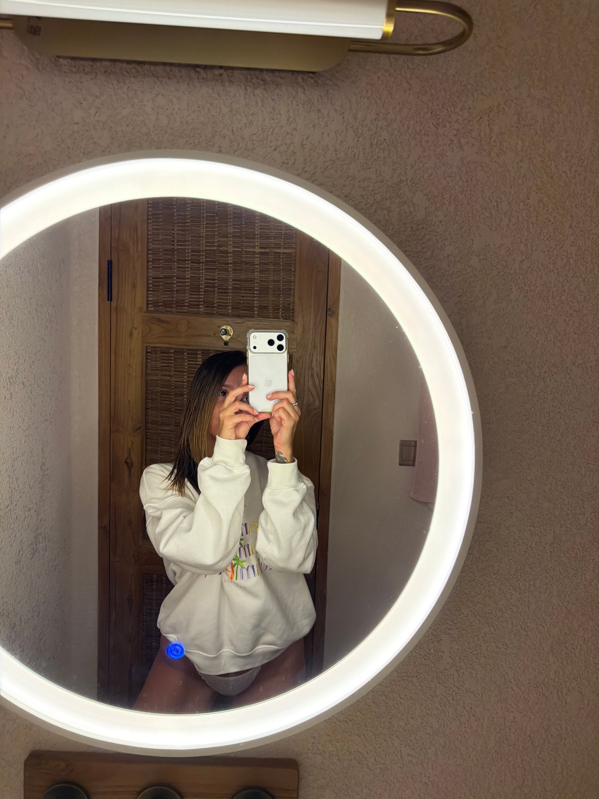 Woman takes bathroom selfies in illuminated mirror in Indonesia