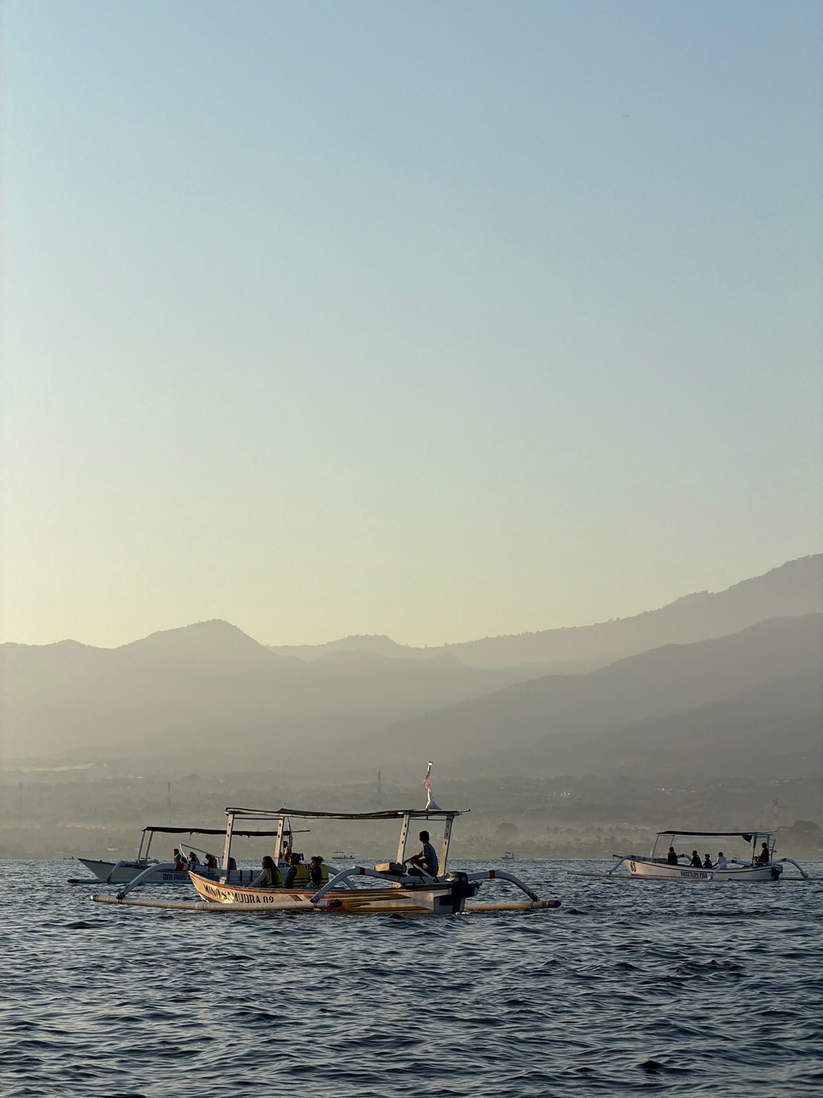 Outrigger boats crossing Buleleng waters at sunset