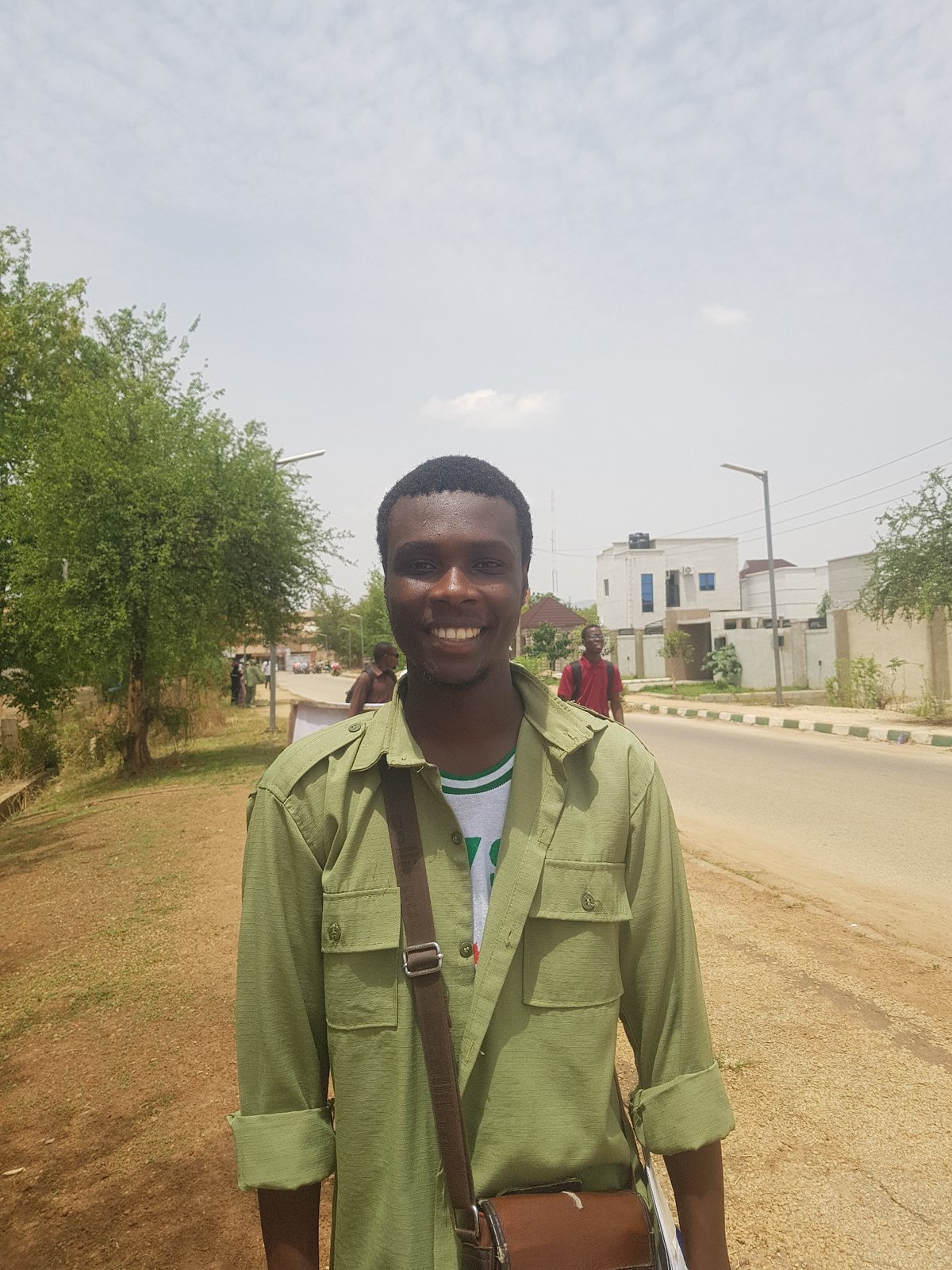 Crowd gathers in Bauchi as motorcycle navigates between cars