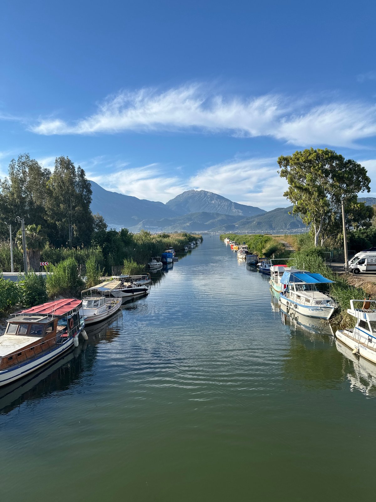 Woman observed on bridge over boat-lined canal in Fethiye
