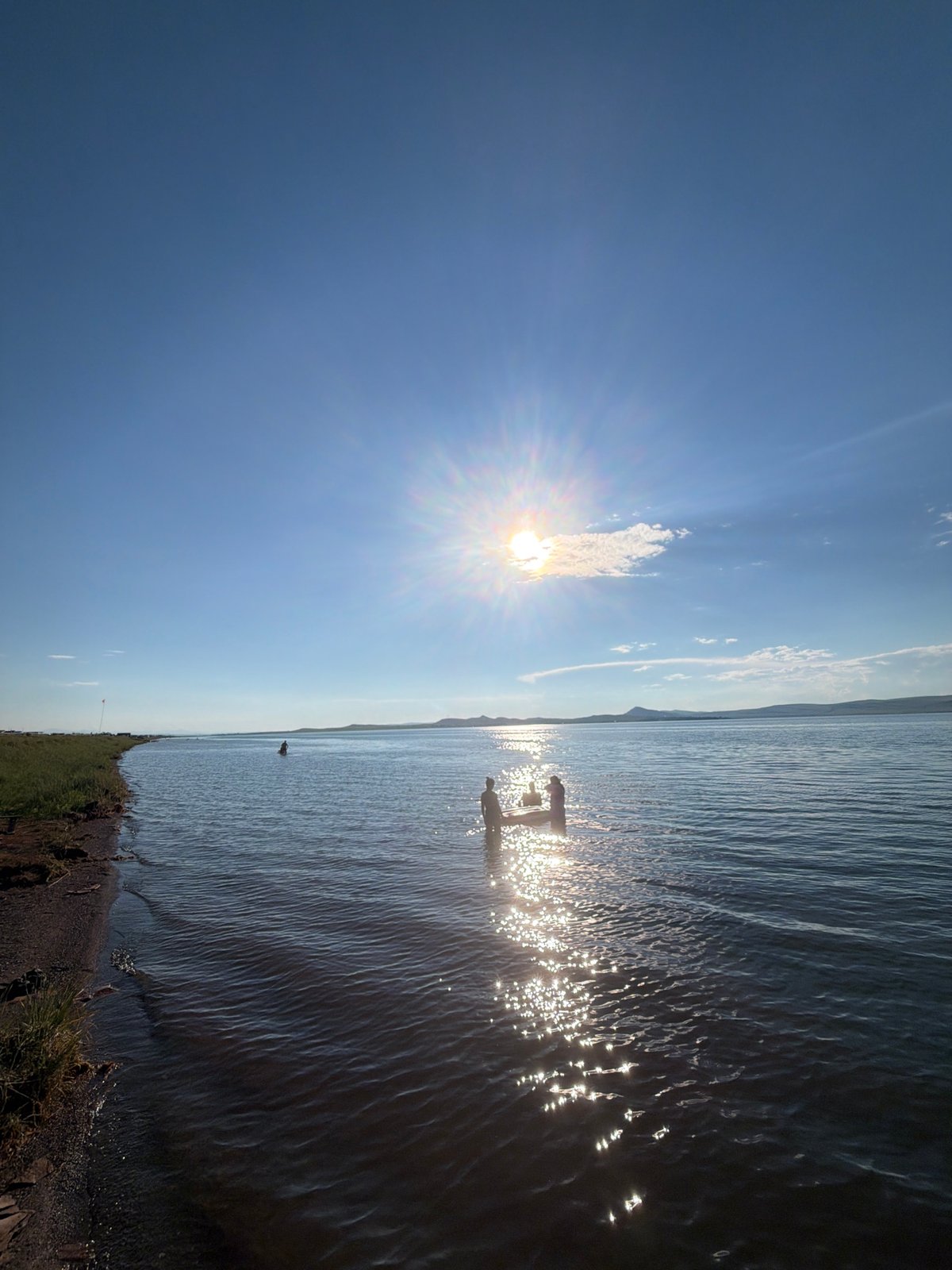 Midday swim at a calm Russian lake on a clear summer day