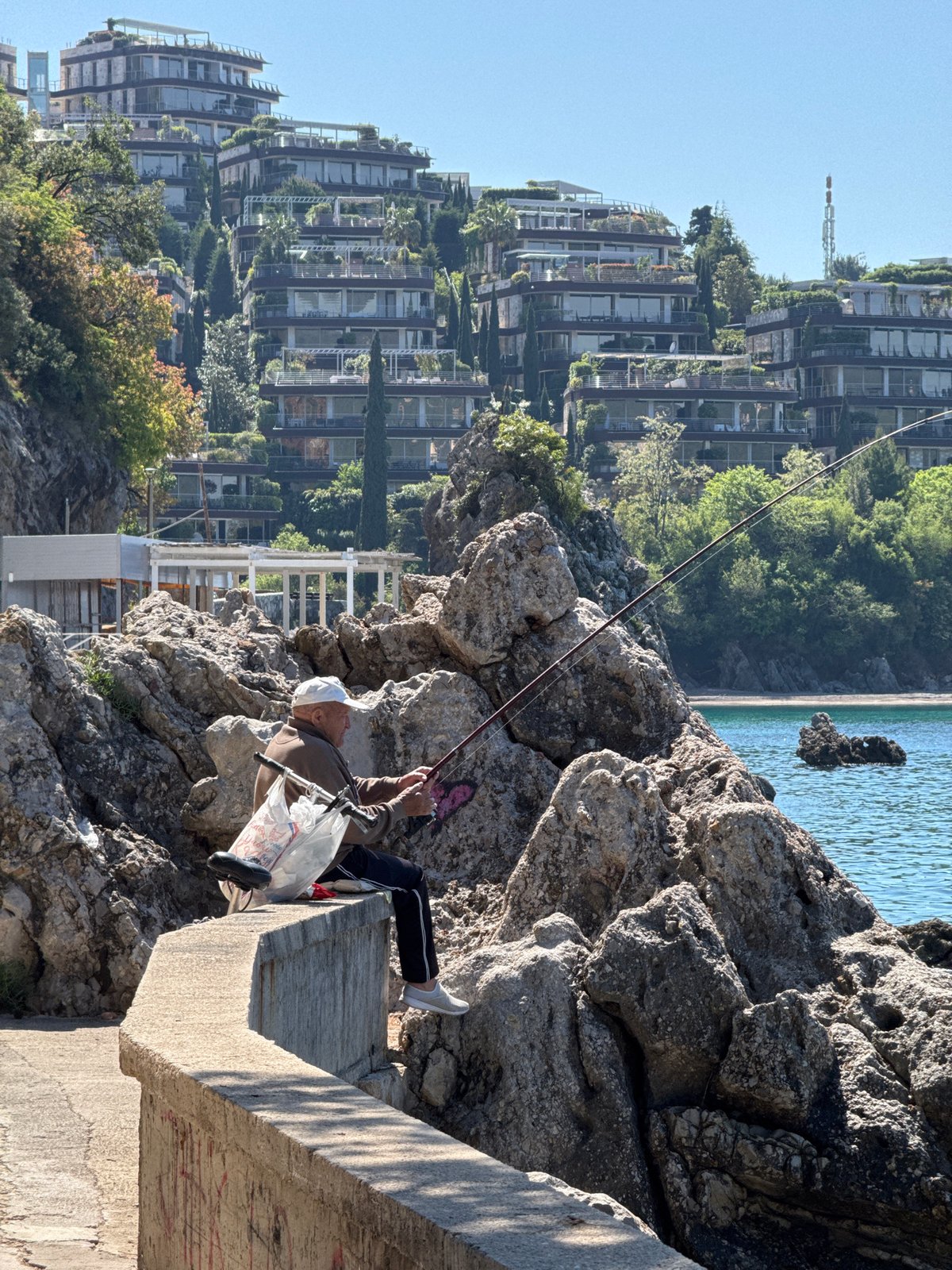 Man fishing from concrete structure in Budva, Montenegro