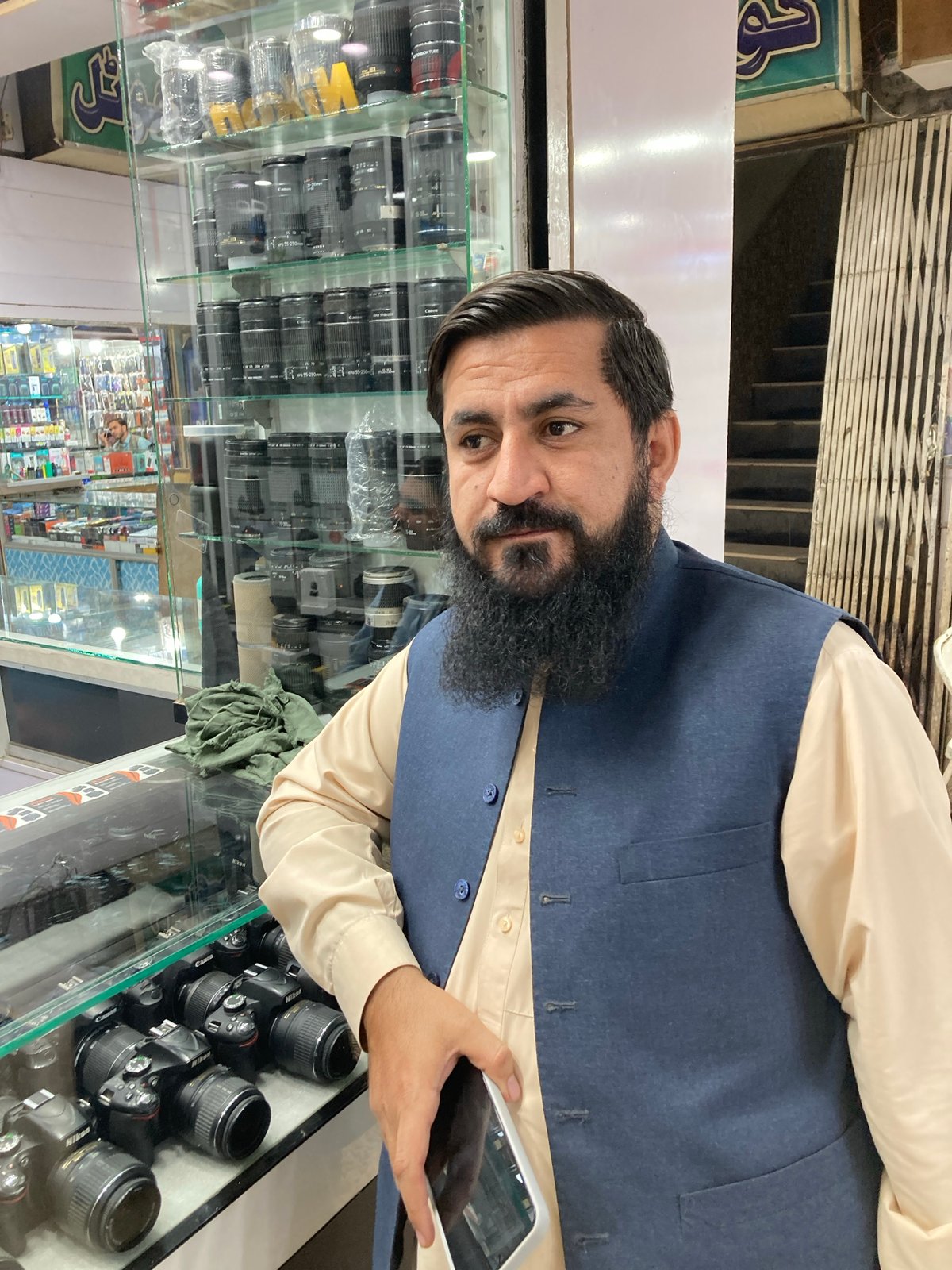 Man browsing camera equipment at electronics store in Quetta