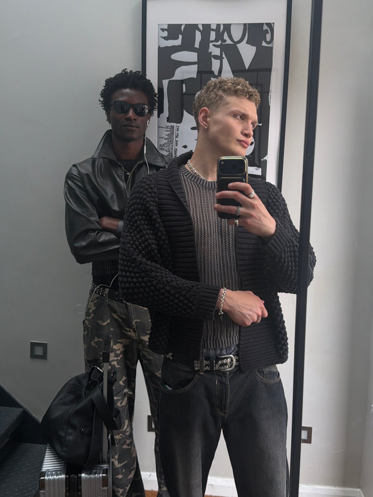 Groups take mirror selfies in London indoor space