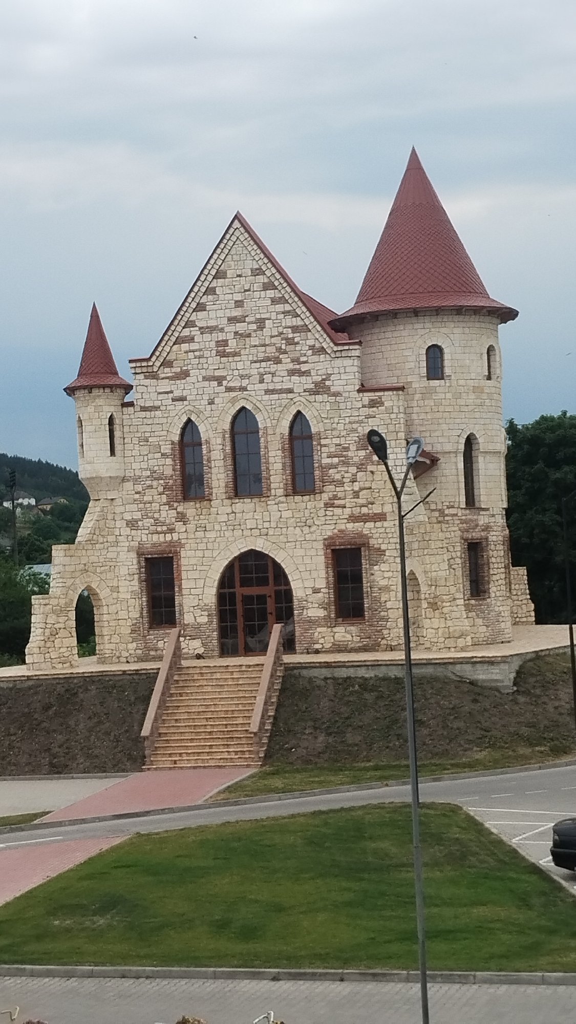 Fairytale stone castle with red conical roof in Berezhany
