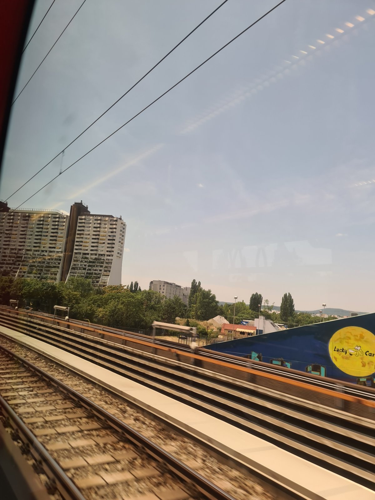 Train window view past Vienna's iconic Hundertwasser architecture