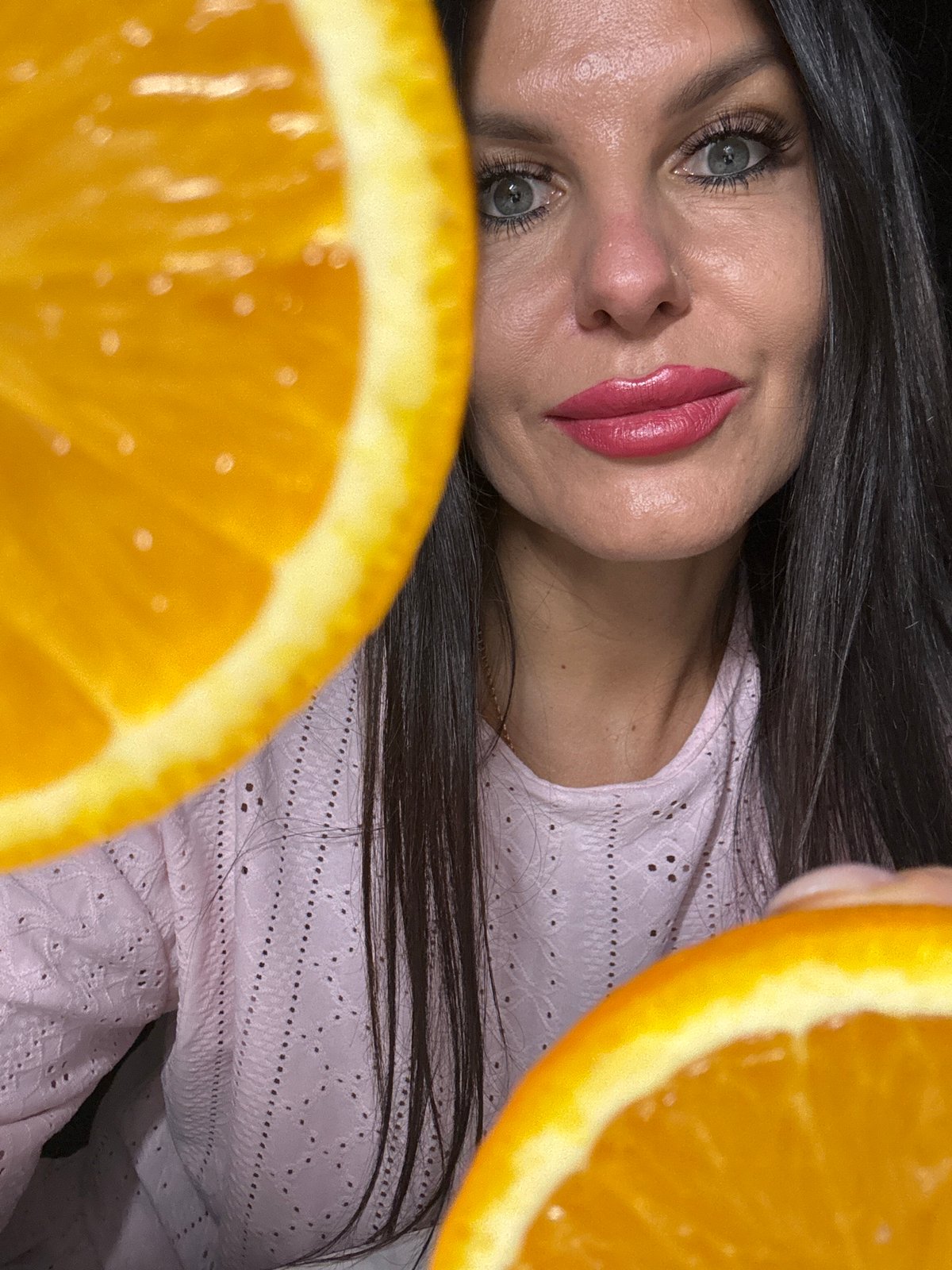 Woman poses with oranges during indoor photo session in Russia