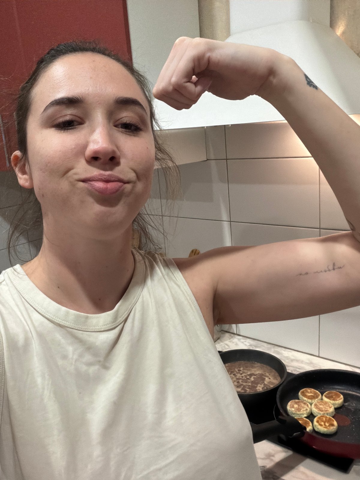 Woman displays butterfly tattoo while flexing in Rostov kitchen