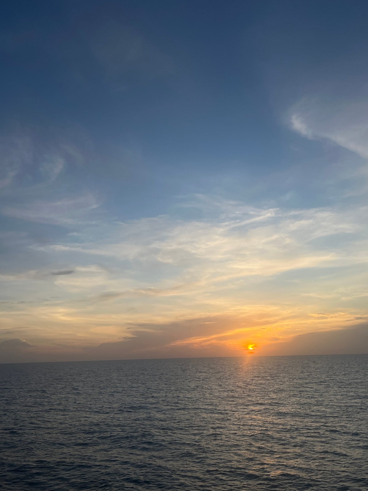 Ocean sunset observed with beverage from waterfront location