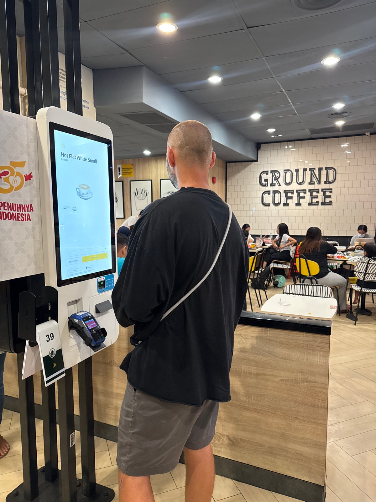 Customer orders coffee at McDonald's kiosk in Kuta Selatan