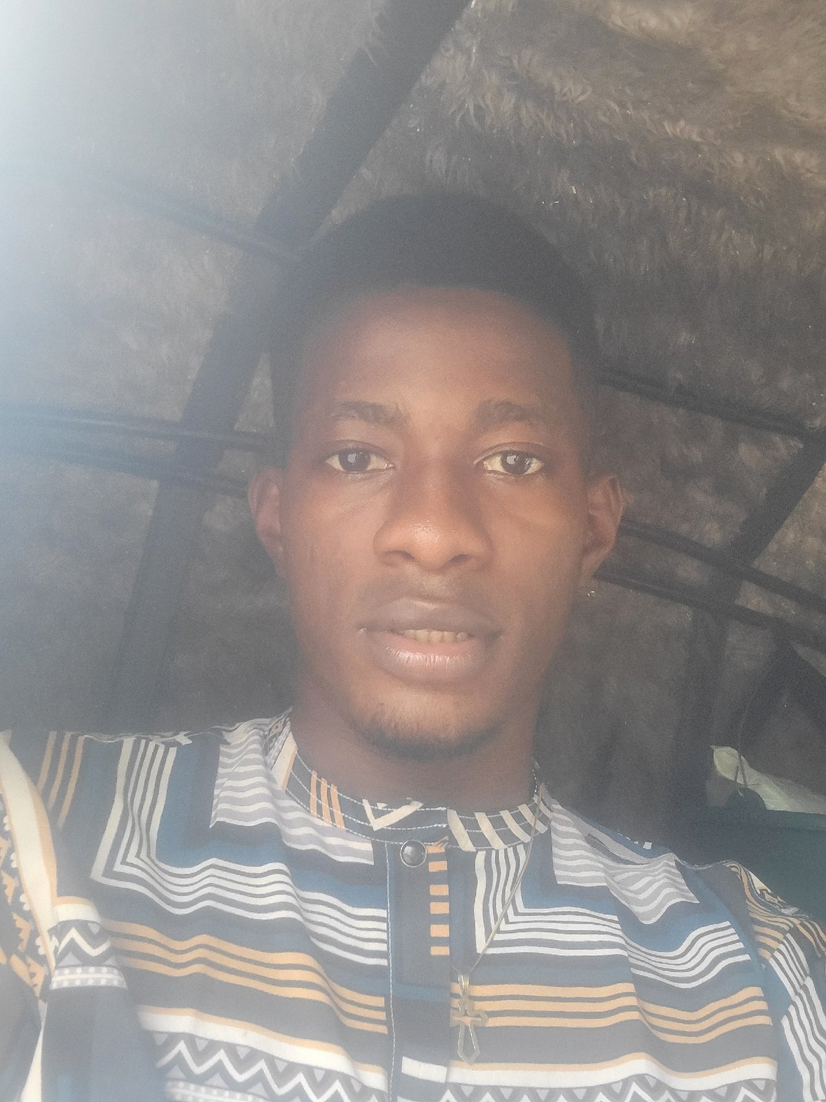 Close-up portrait in Egbagu, Nigeria, bold geometric shirt
