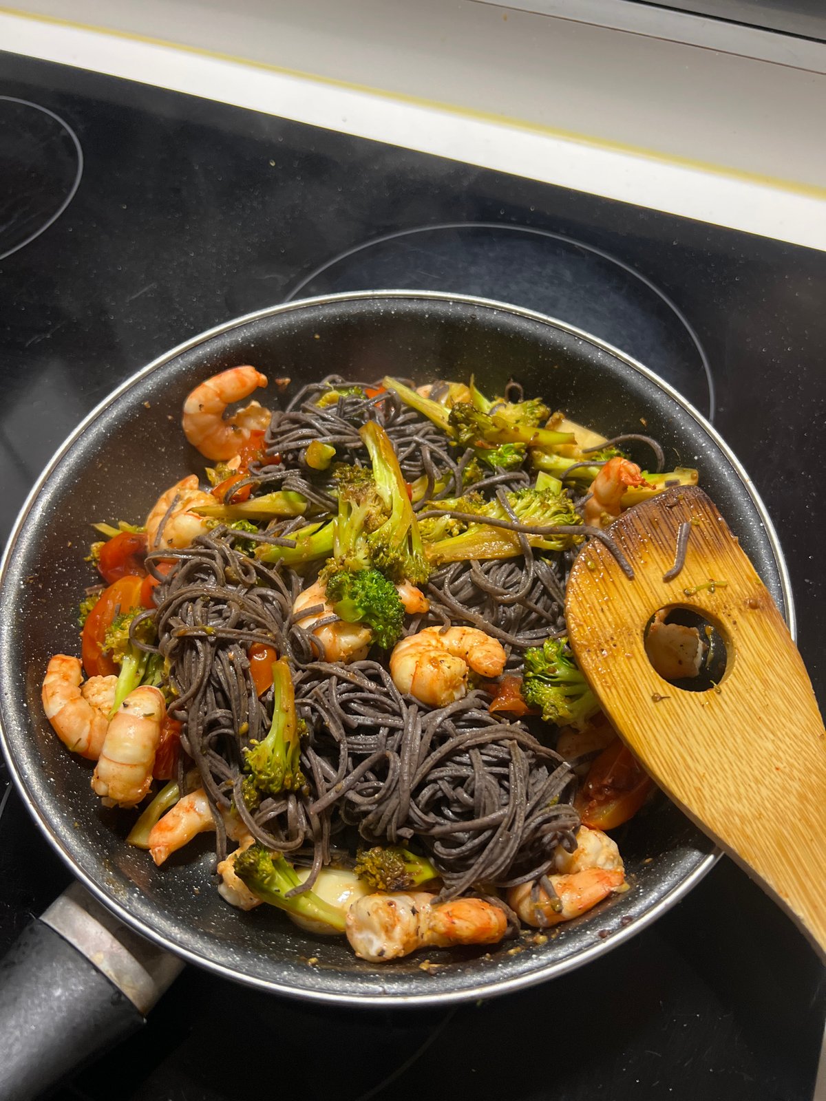 Woman documents cooking dark pasta meal in Paris kitchen