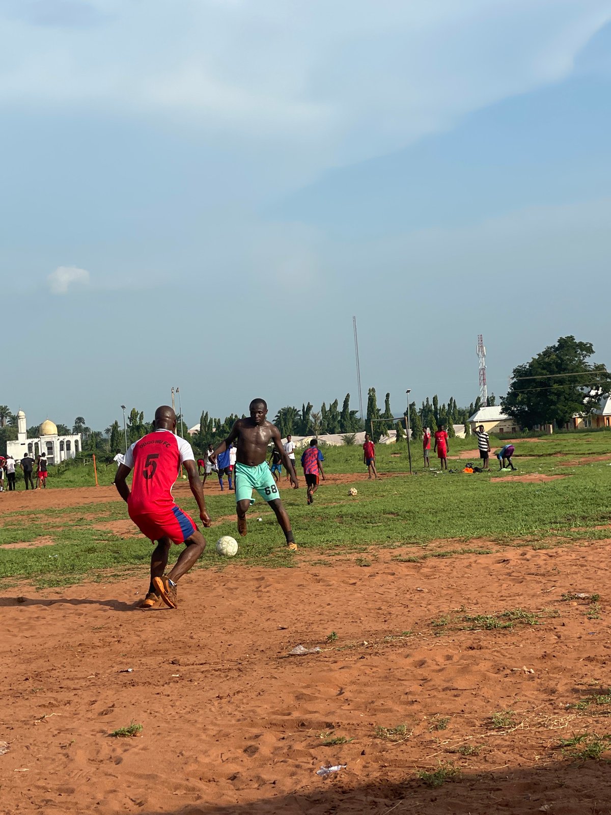 Afternoon soccer match played on dirt field in Ogbogbo