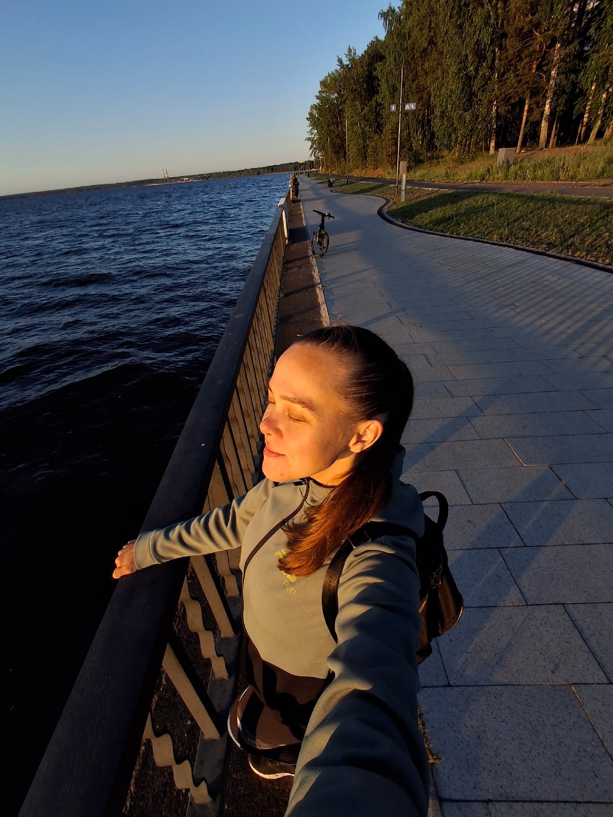 Woman documents leisurely day at Kama River waterfront in Russia