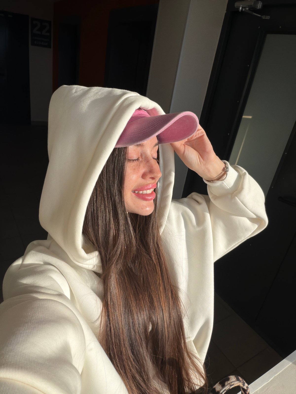 Young woman in pink cap spotted smiling in Saint Petersburg