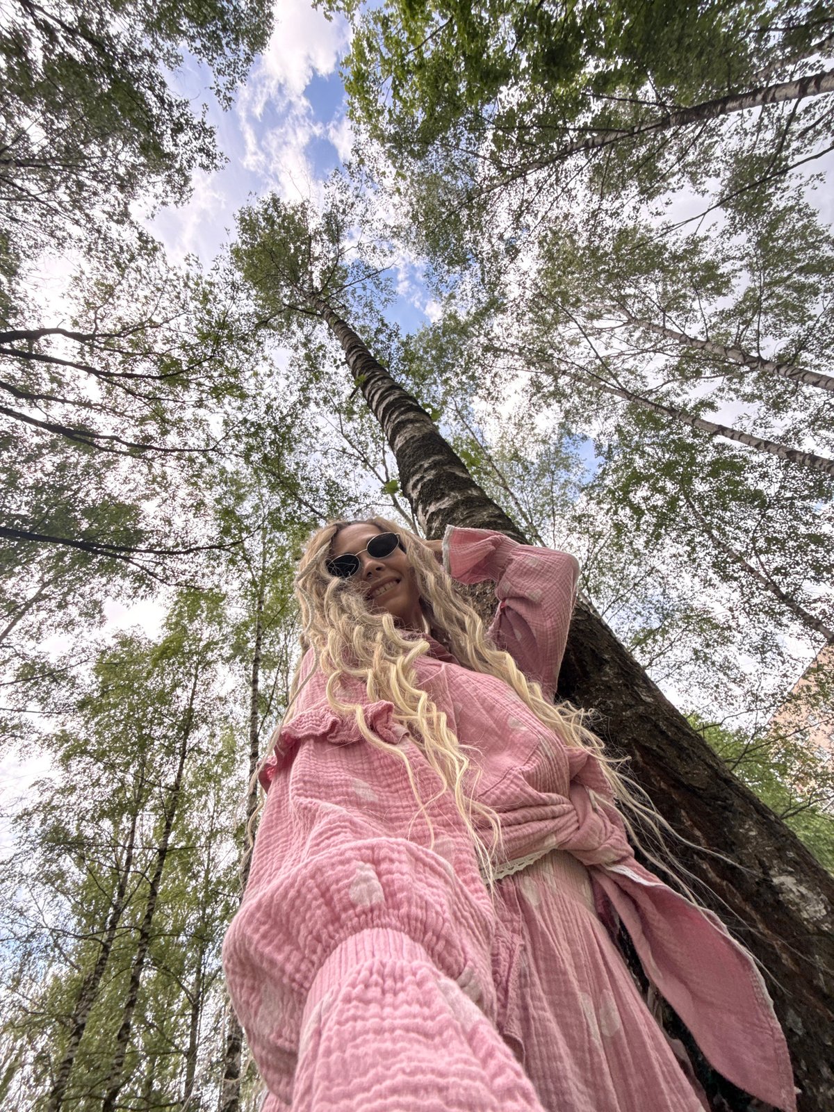 Woman takes morning selfies in Russian birch grove