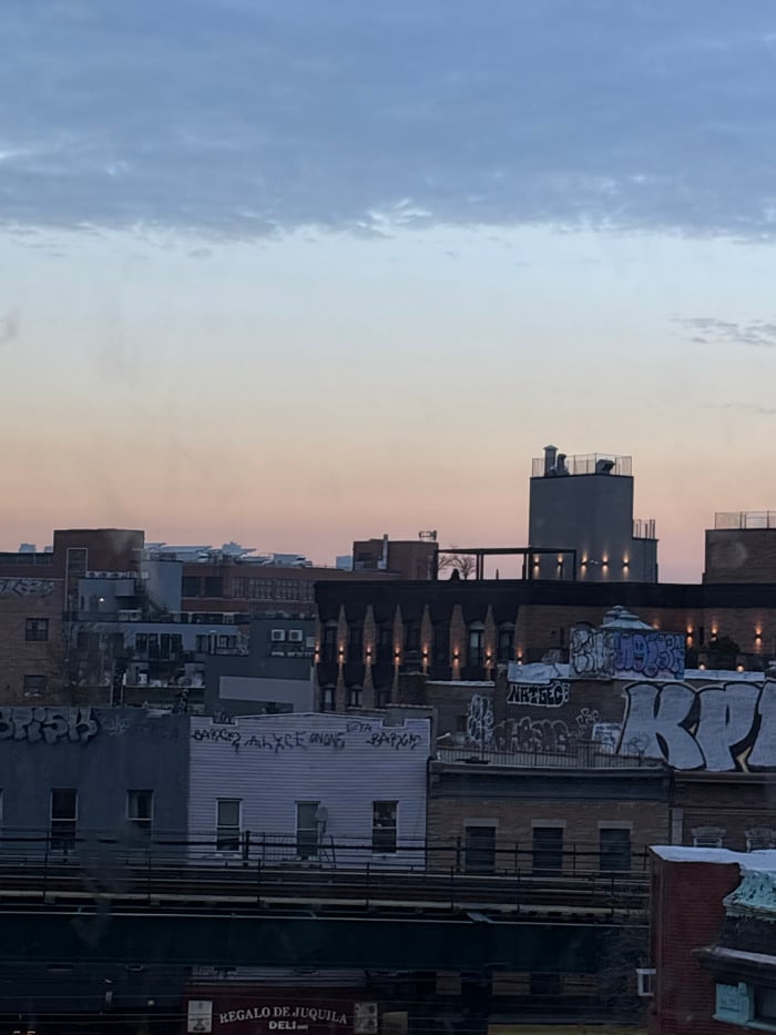 NYC skyline observed under gradient blue-orange evening sky