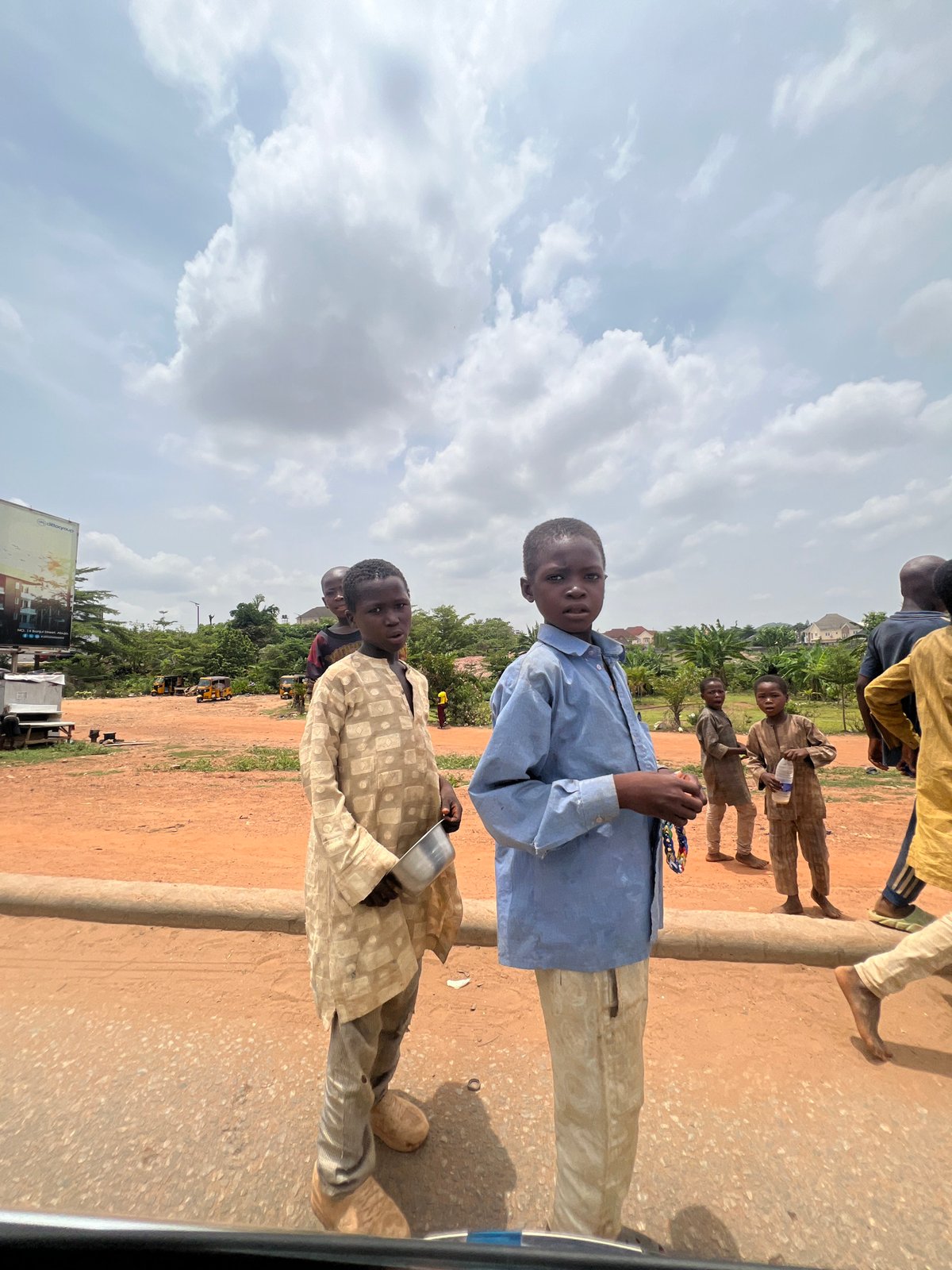 Young boys gather near dirt road in Abuja