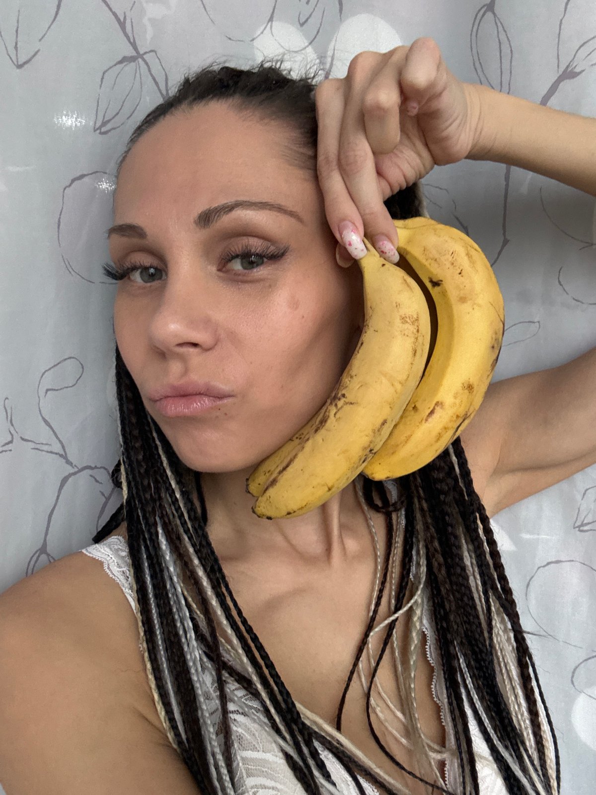 Woman poses playfully with bananas and plants in Rusanovo bedroom