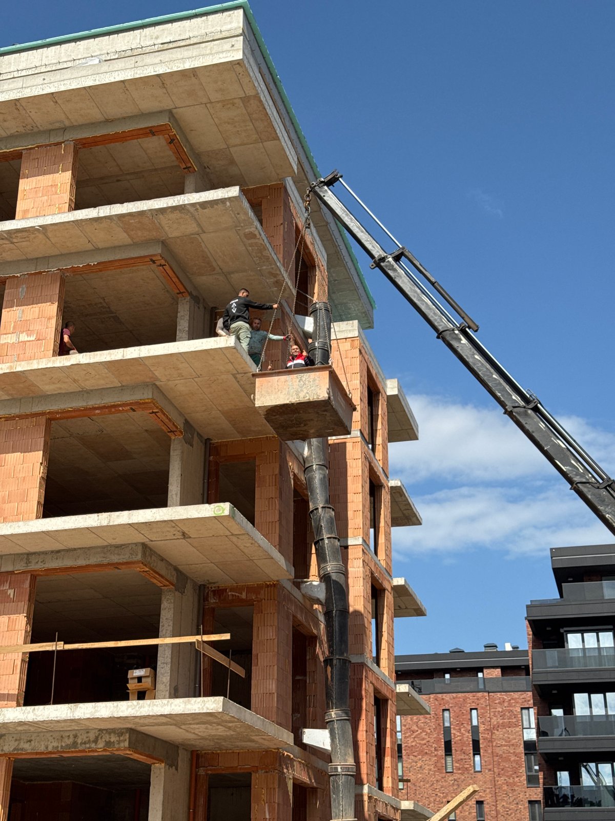 Construction site with multi-story building framework and crane documented