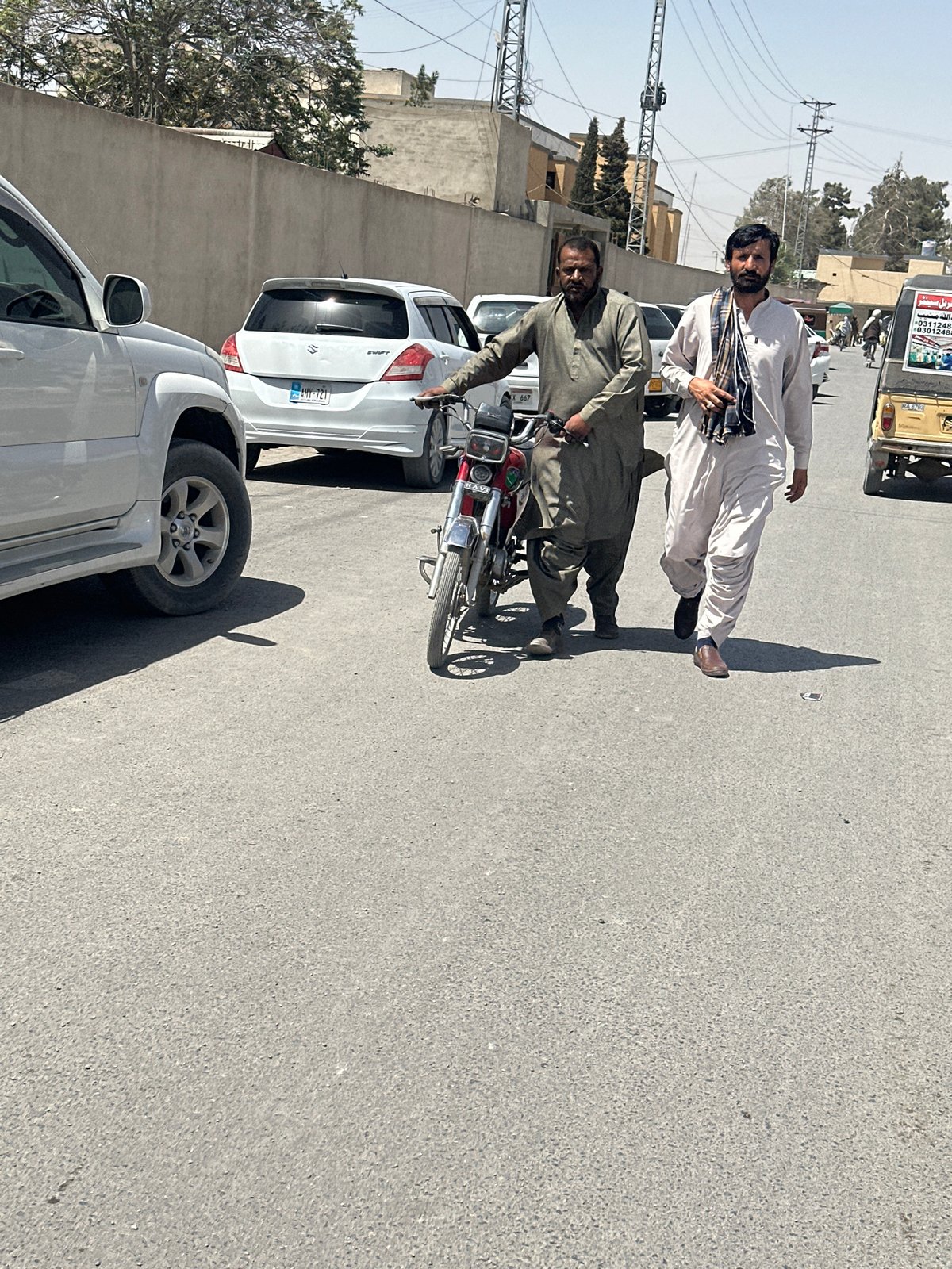 Morning street activity observed in Quetta: motorcycle conversation, cart transport