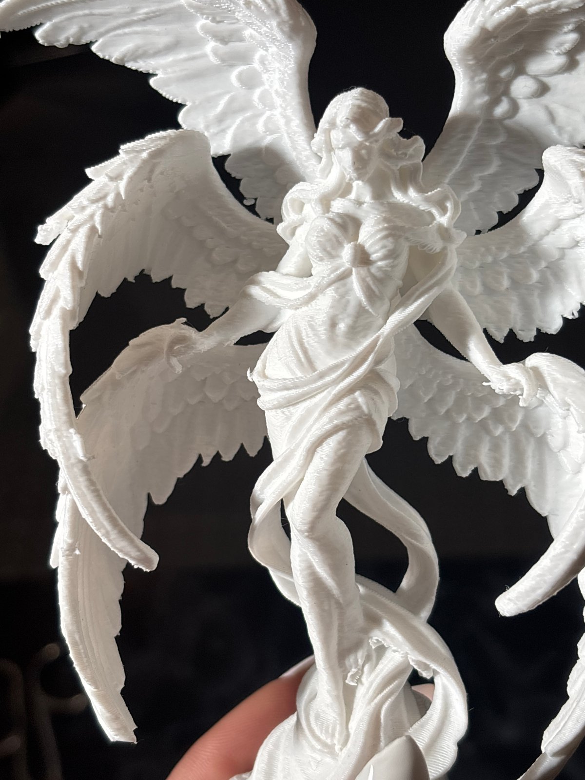 Person examines 3D-printed angel figurine in Sofia