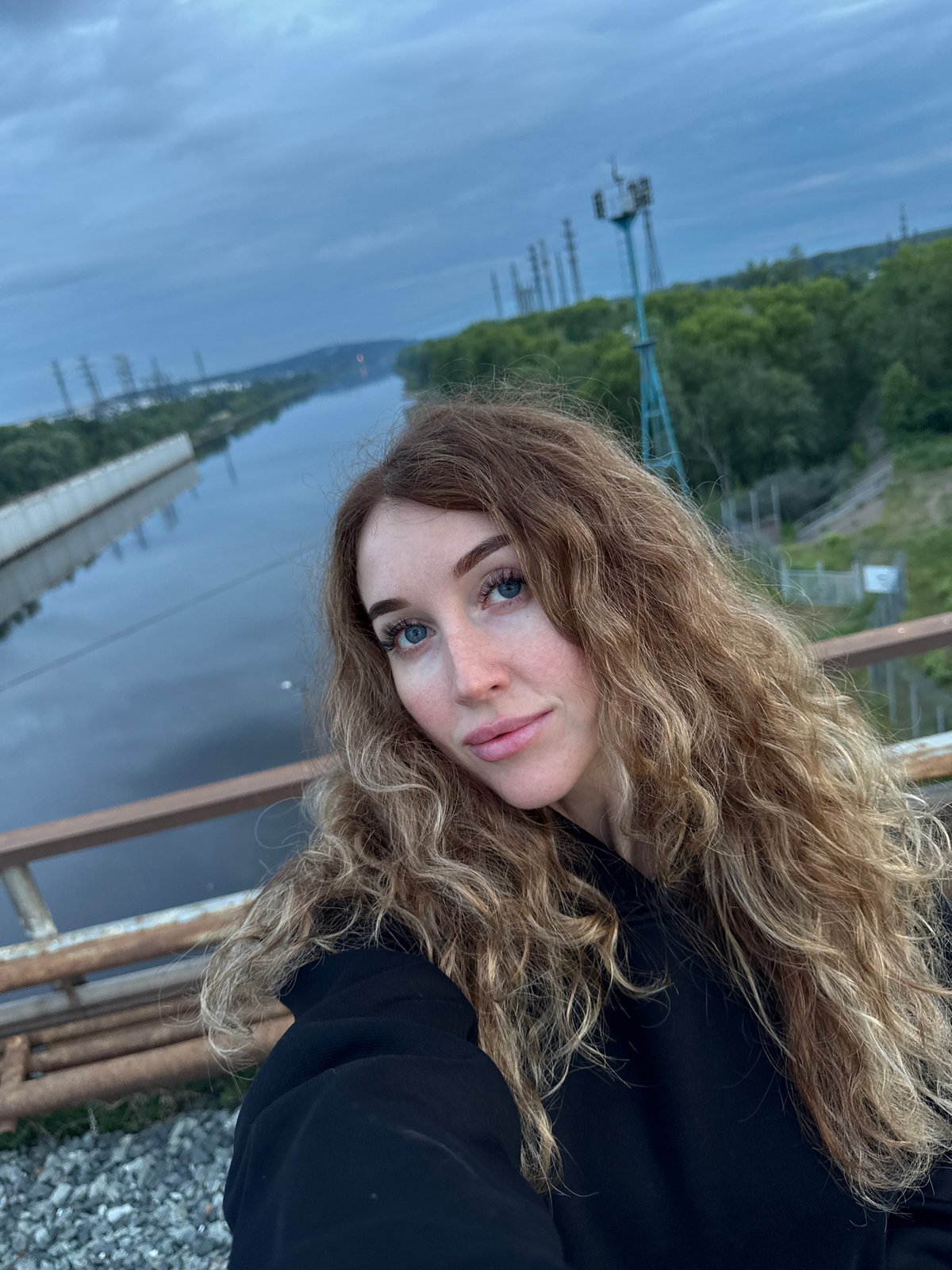 Exploring a fenced industrial riverfront in Chaikovsky with a Samoyed