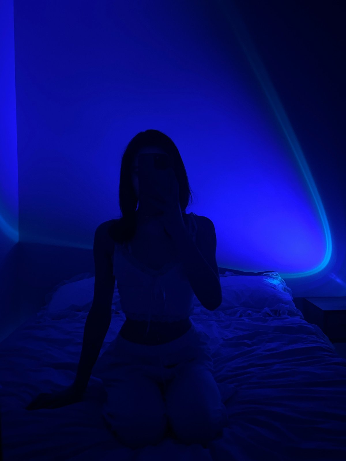 Blue-lit bedroom, phone in hand, quiet evening in Ternopil