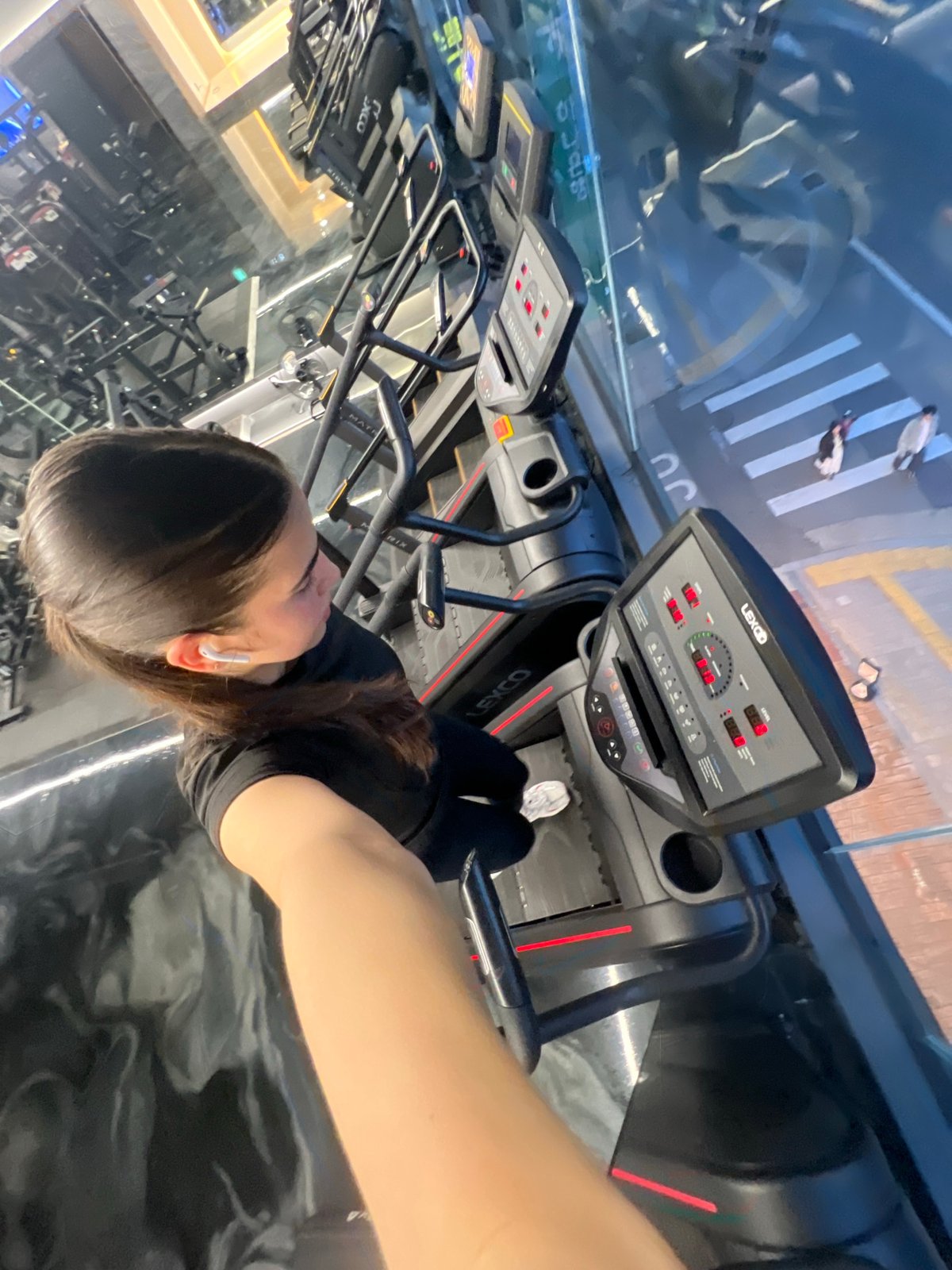 Woman exercises on treadmill at Daegu gym with city view