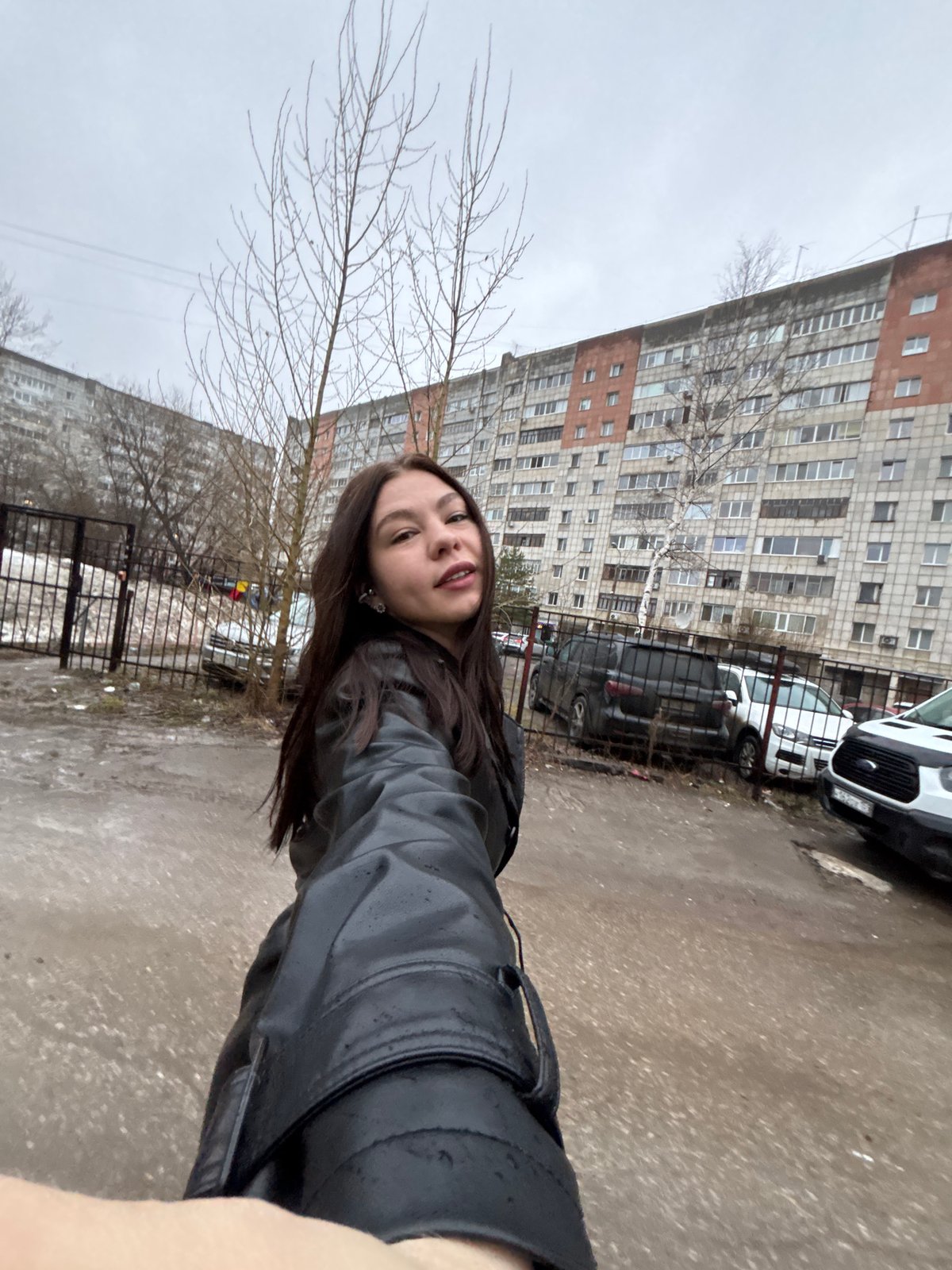 Woman takes selfie outside apartment building in Perm