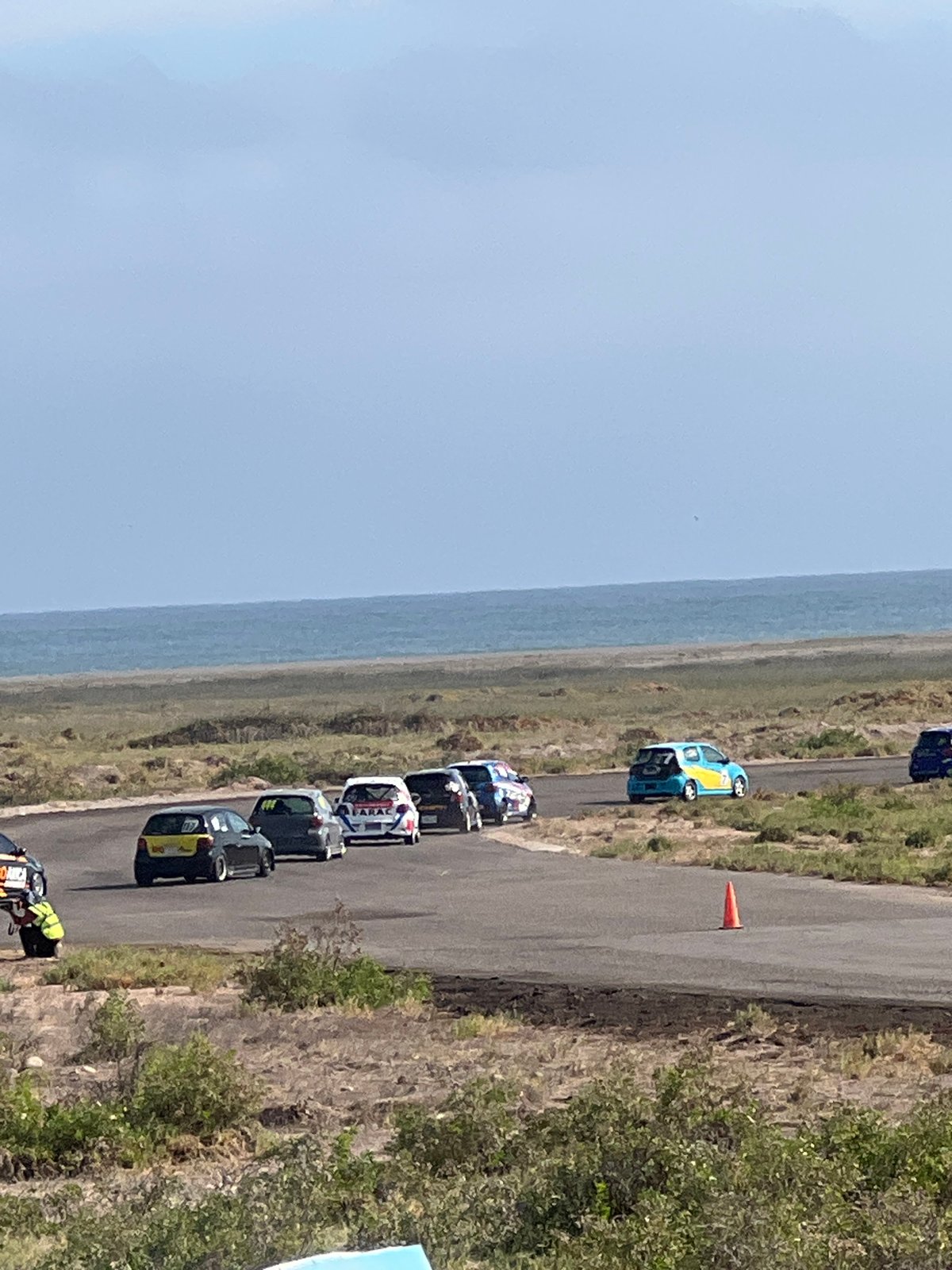 Race day at Arica's coastal track, cars and flags everywhere