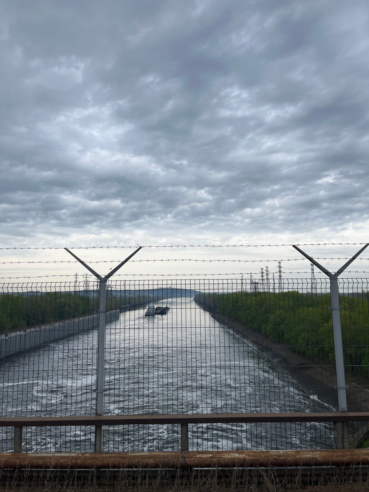 Fenced waterway view captured in Chaikovsky, Russia early morning