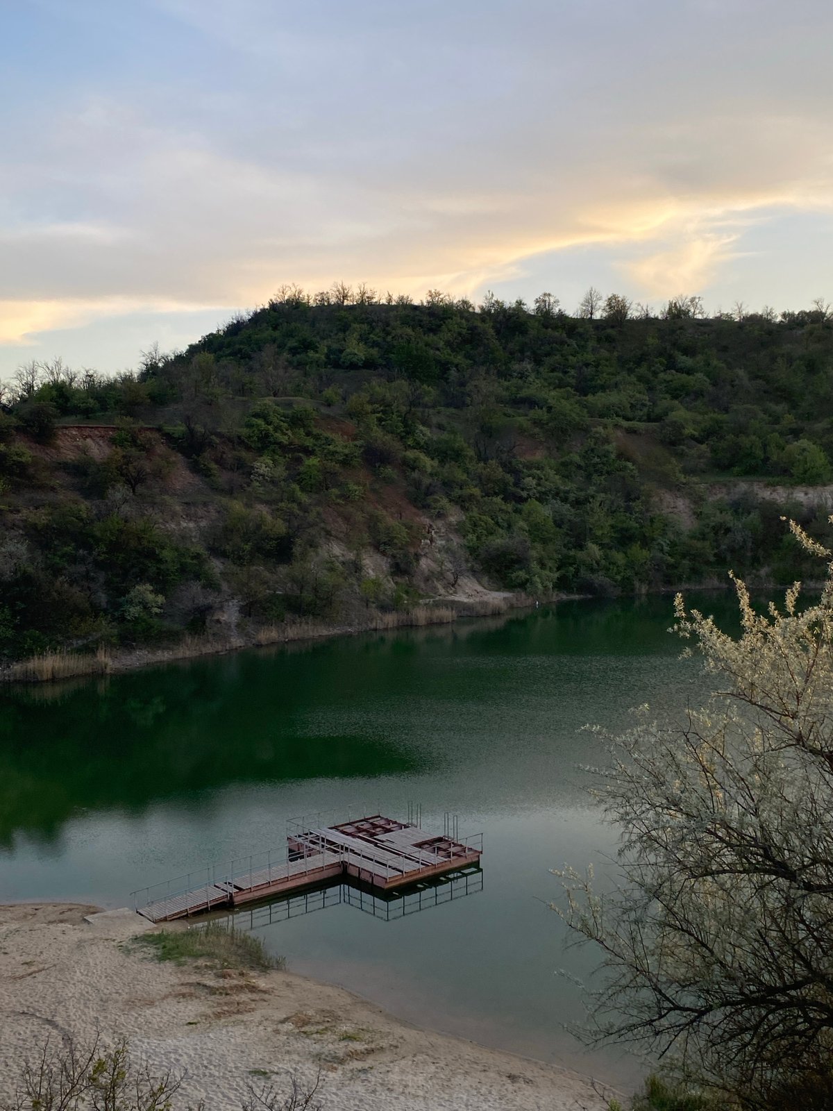 Lake sunset scene photographed with dock and hillside backdrop