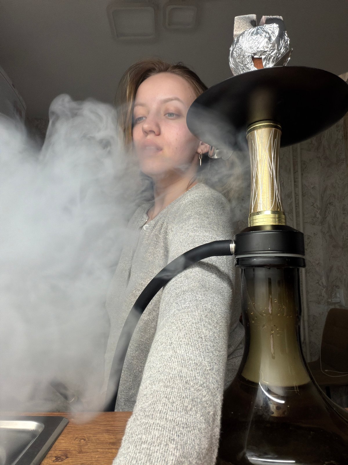 Woman smoking hookah indoors captured in Reshetnikovo, Russia