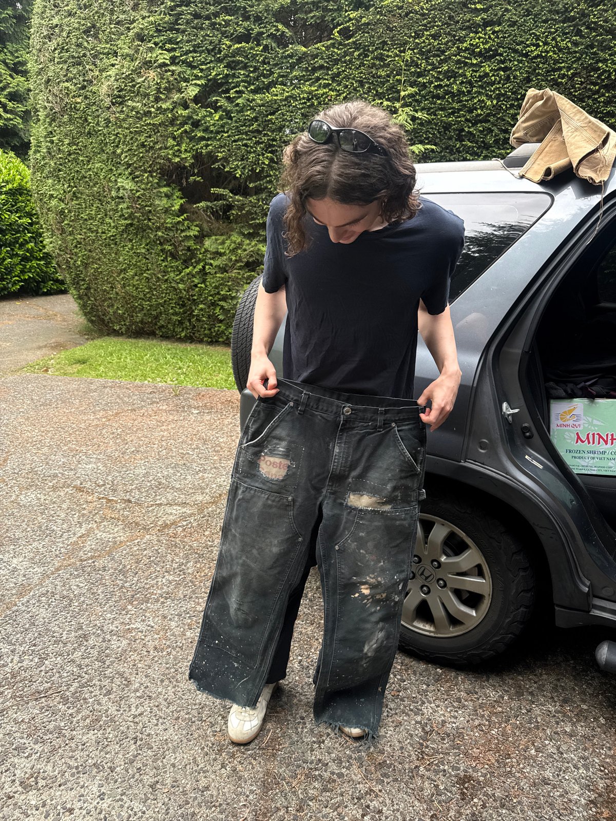Person handles clothing at vehicle trunk in North Vancouver