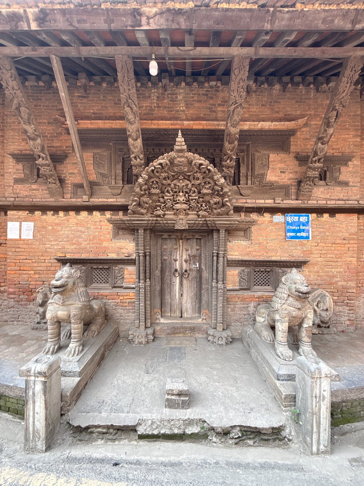 Traditional carved lions guard ornate doorway in Kathmandu