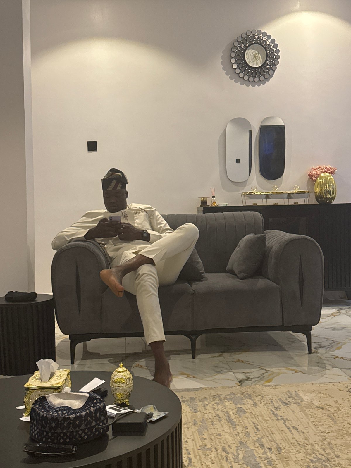 Two men relax on gray sofa in modern living room