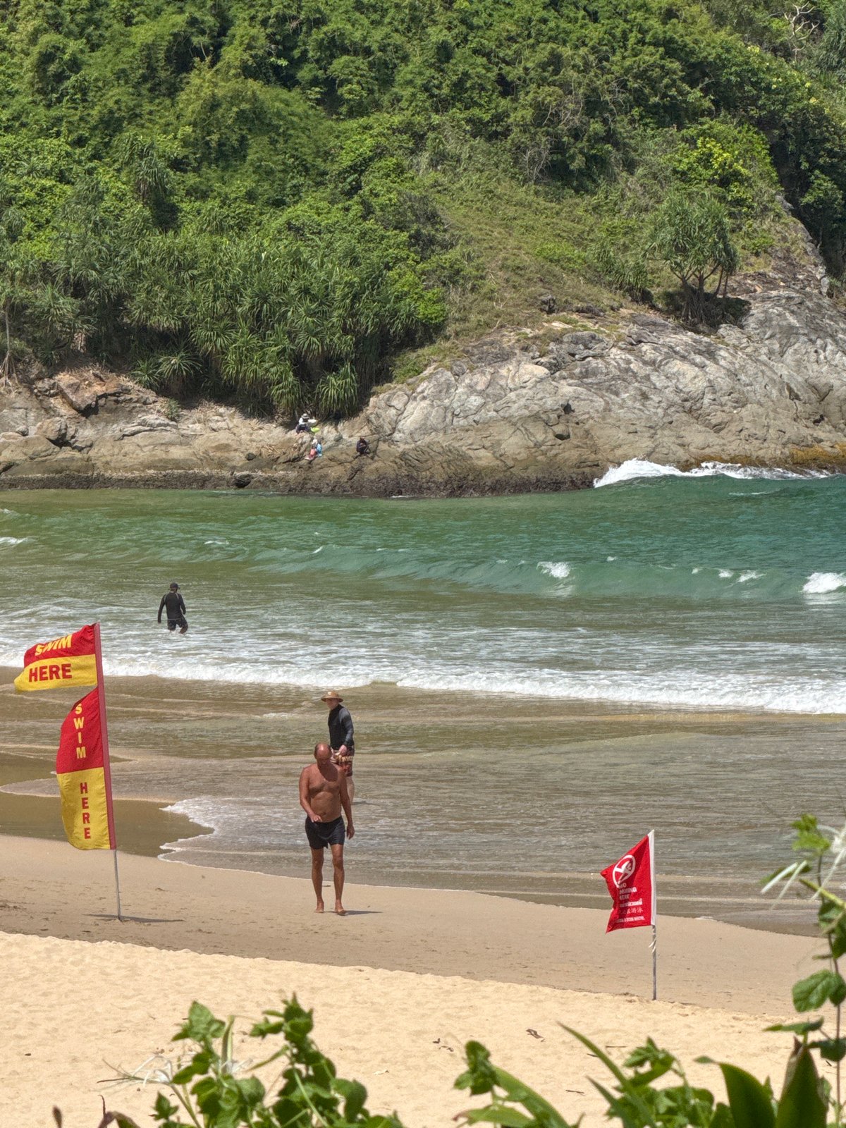 Quiet morning at Rawai Beach, swim flags up, skies clear