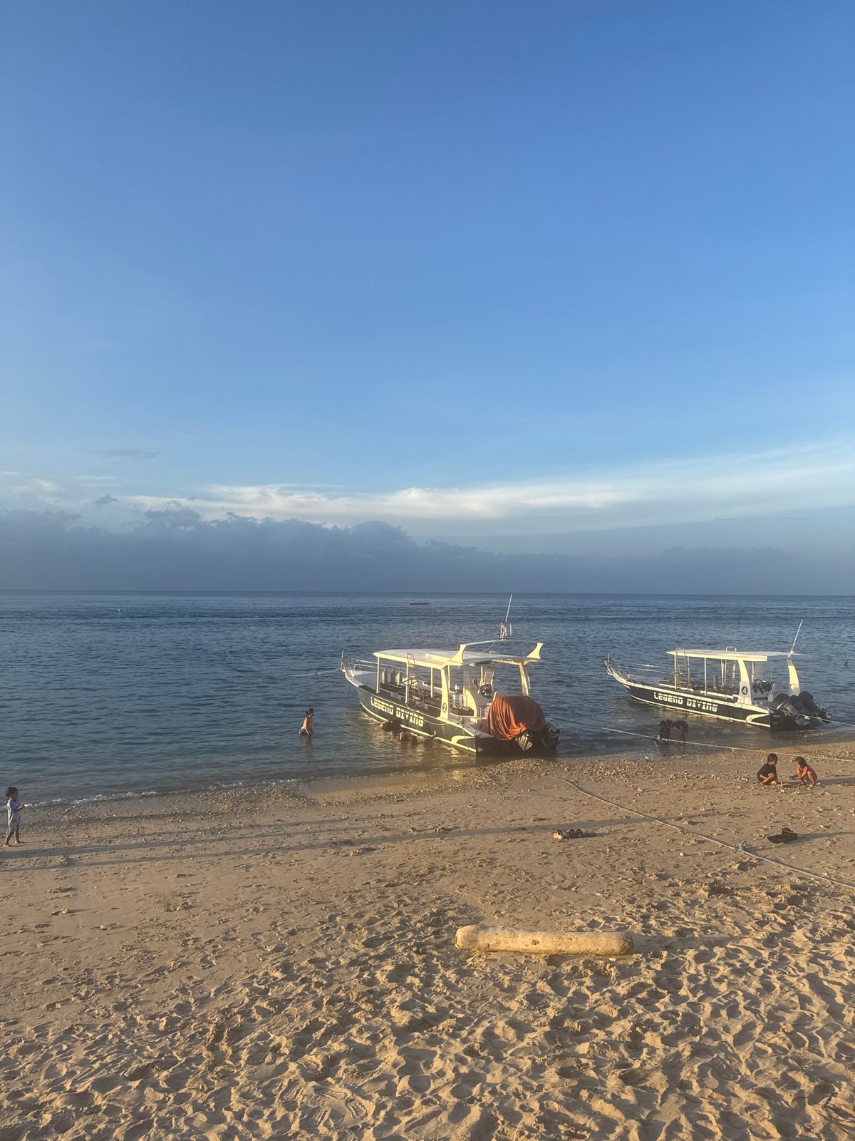 Beach sunset and children's kite play documented on Nusa Penida
